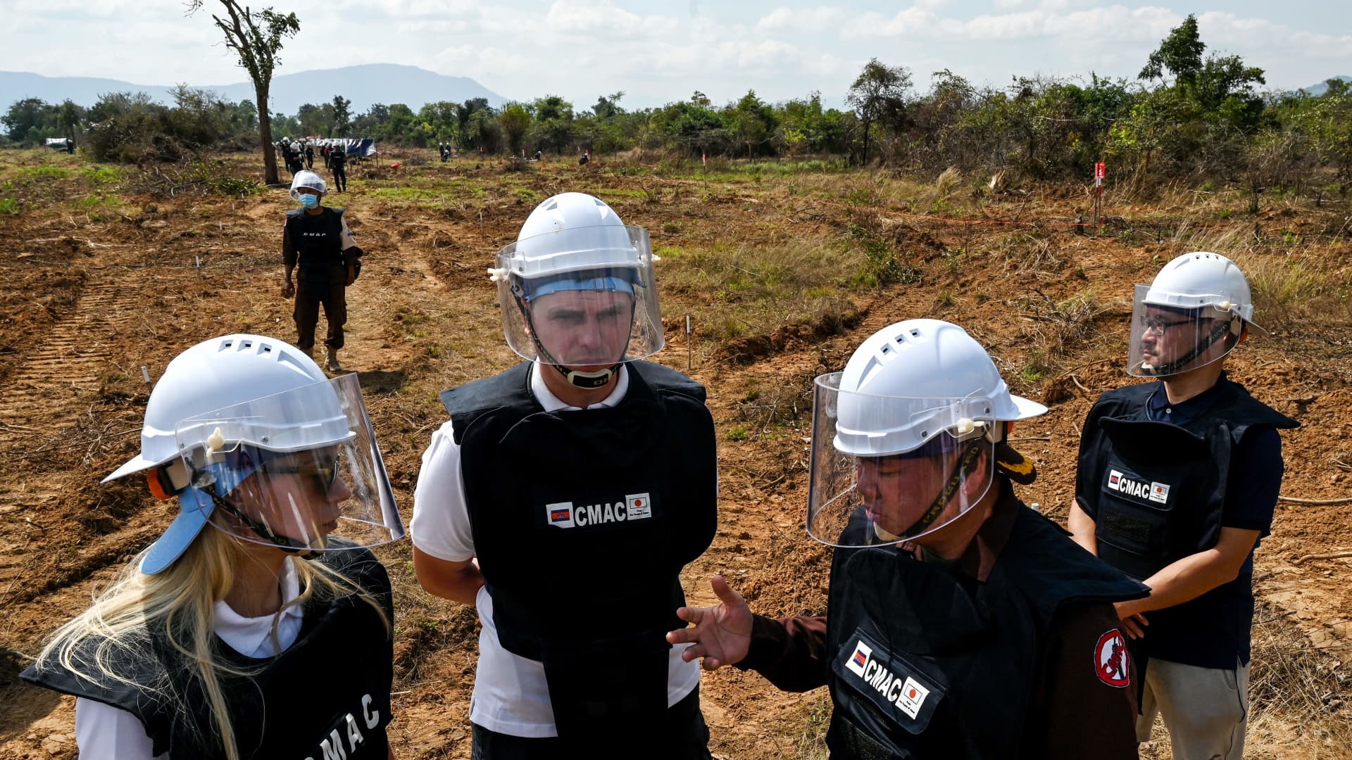 Ukraine deminers (L) listen to a Cambodian deminer (2R) at a mine field during a technical training session on demining technologies in Battambang province on January 19, 2023. 