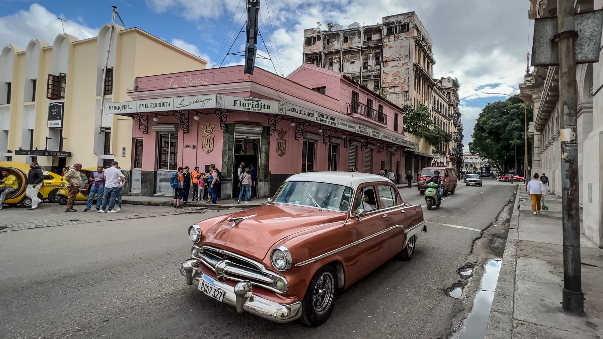 An old American car passes by the Floridita bar in Havana on December 27, 2022.