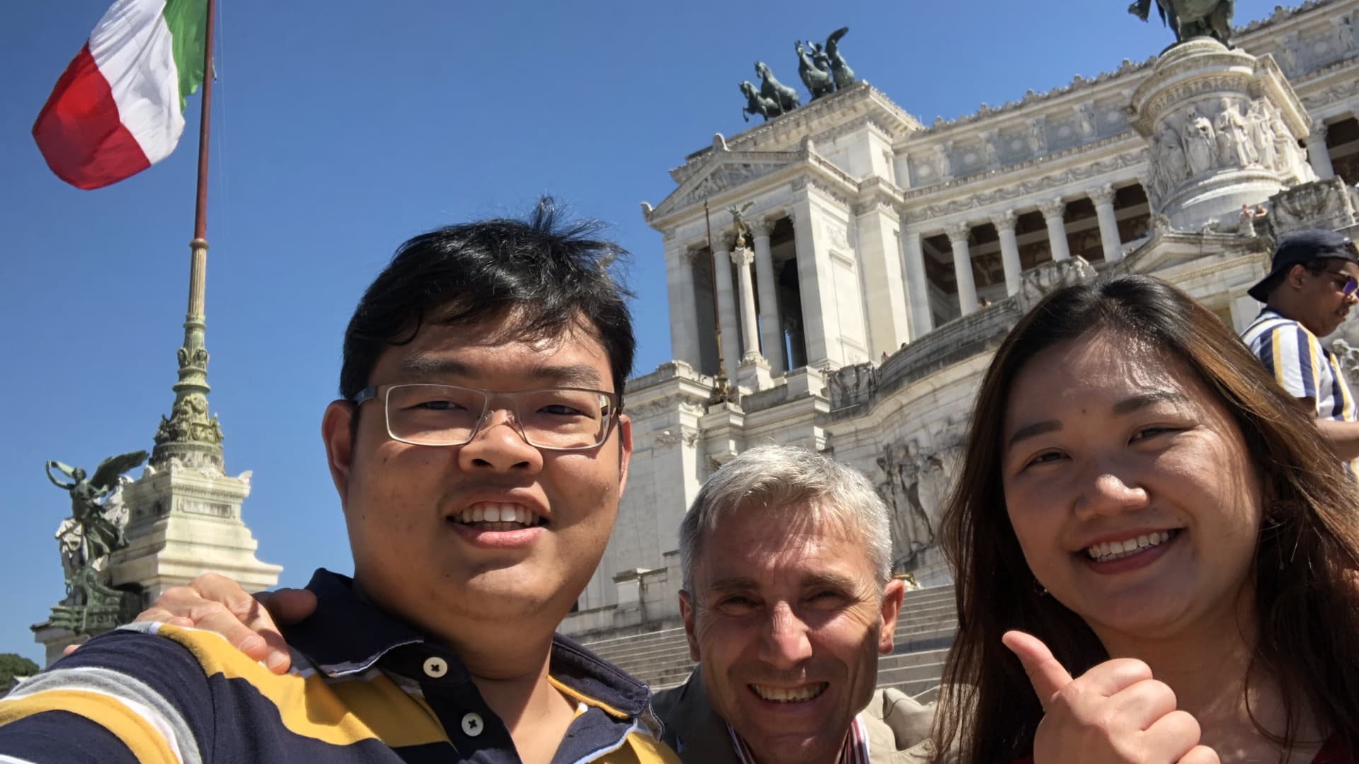 Giuseppe D'Angelo (center) shown here with travelers in front of the Victor Emmanuel II National Monument in Rome.