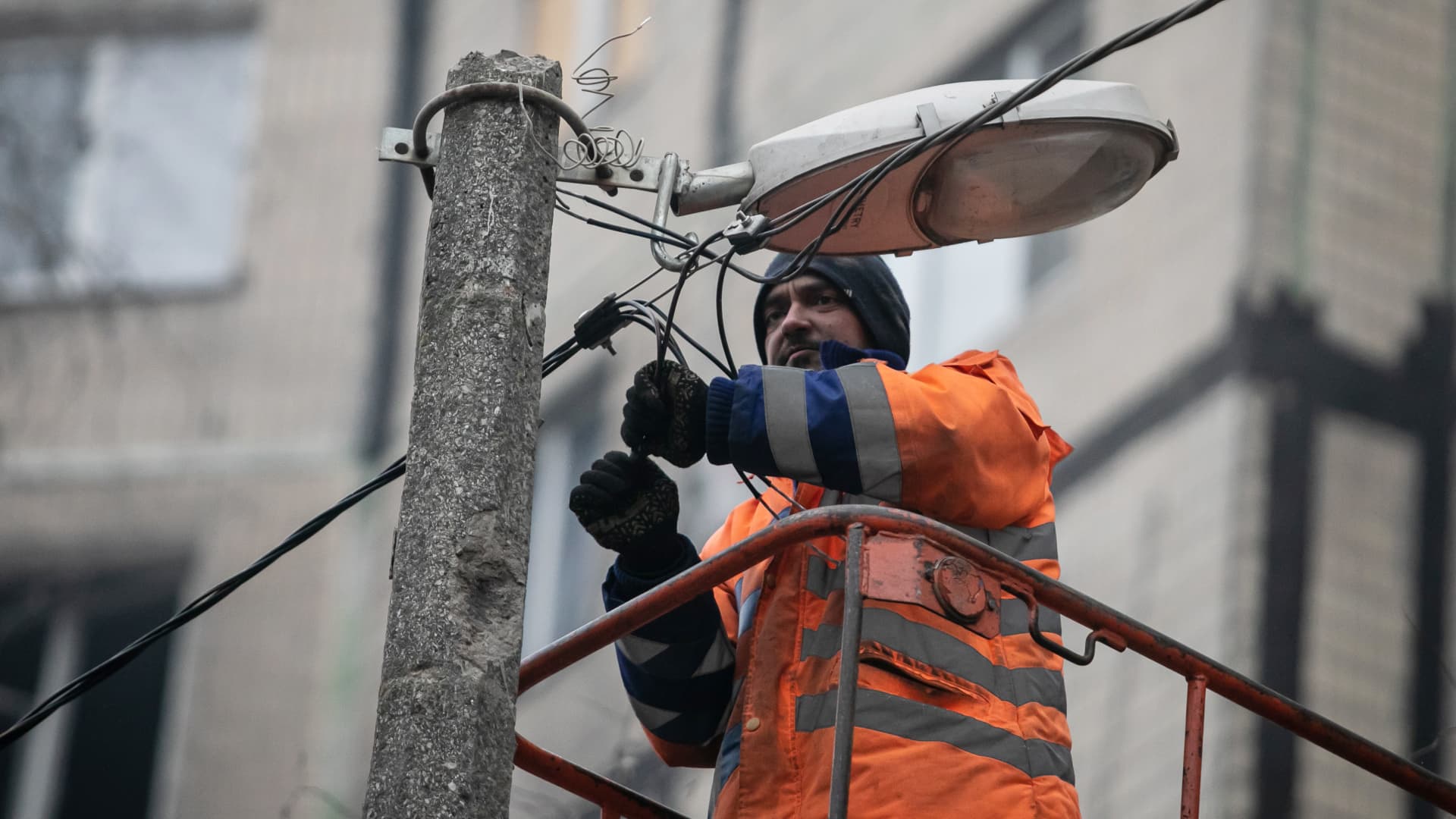 Utility man on the platform of a cherry picker truck repairs electricity on January 15, 2023 in Dnipro, Ukraine.