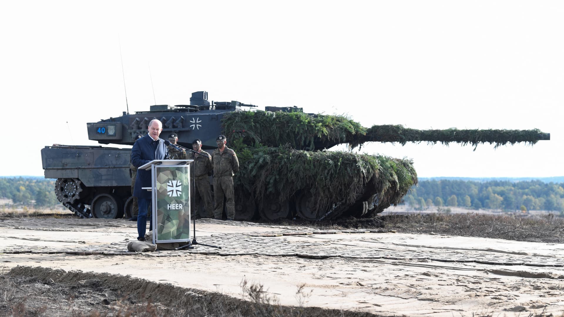 German Chancellor Olaf Scholz delivers a speech in front of a Leopard 2 tank during a visit to a military base of the German army Bundeswehr in Bergen, Germany, October 17, 2022. 