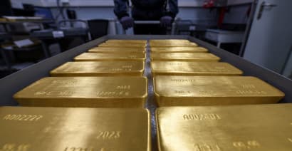 Gold trims gains after U.S. Fed signals more rate hikes 