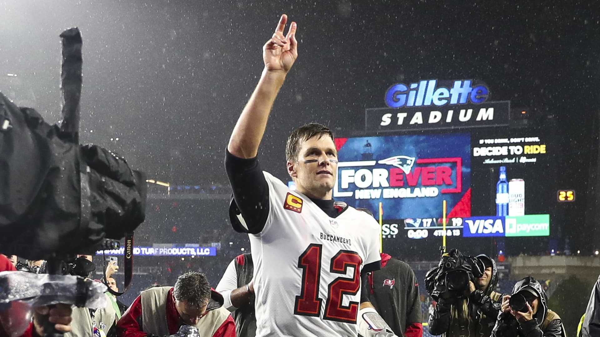 Tom Brady #12 of the Tampa Bay Buccaneers waves to the crowd as he runs off the field after defeating the New England Patriots in the game at Gillette Stadium on October 03, 2021 in Foxborough, Massachusetts.
