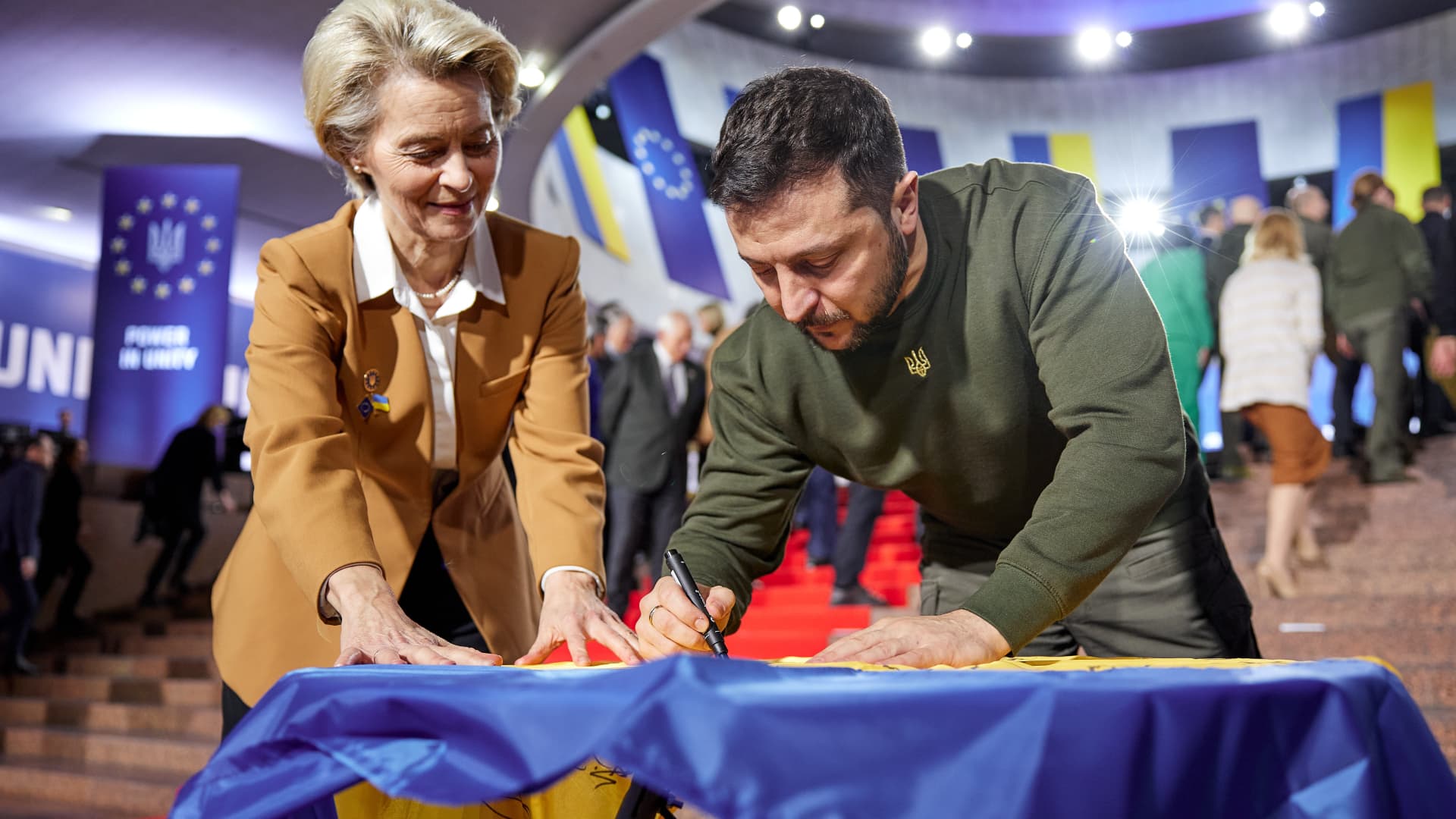 Ukrainian President Volodymyr Zelenskyy (R) and European Commission President Ursula von der Leyen (L) sign a Ukrainian flag after their meeting in Kyiv, Ukraine on February 02, 2023.