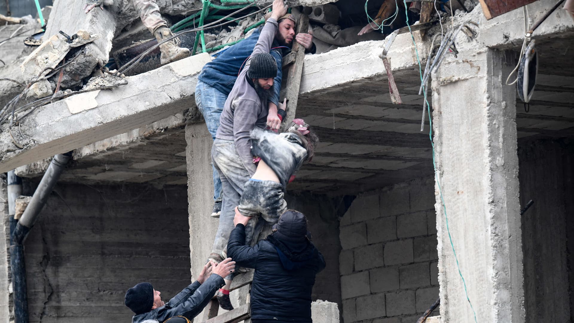 Residents retrieve an injured girl from the rubble of a collapsed building following an earthquake in the town of Jandaris, in the countryside of Syria's northwestern city of Afrin in the rebel-held part of Aleppo province, on February 6, 2023.