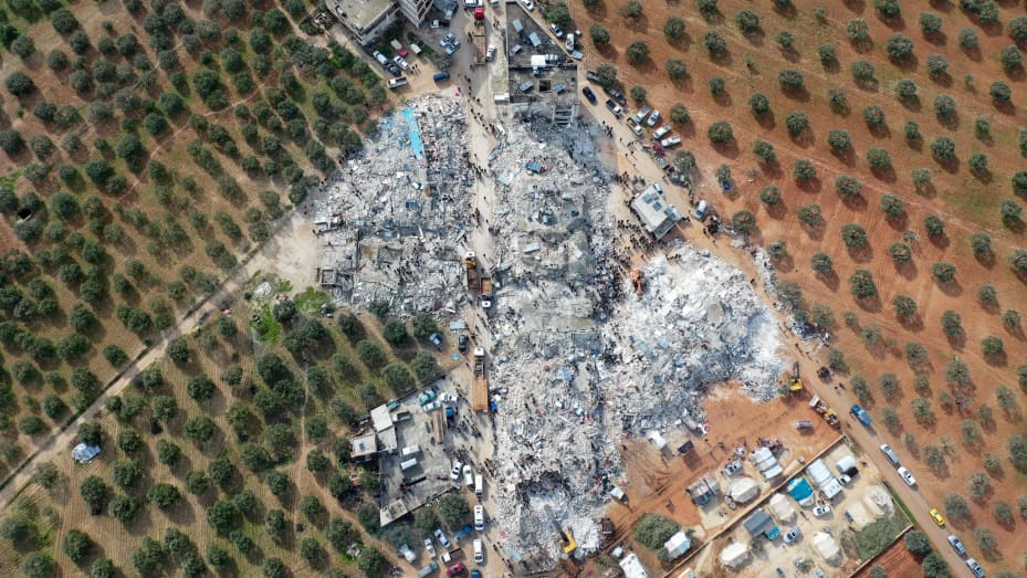 TOPSHOT - This aerial view shows residents searching for victims and survivors amidst the rubble of collapsed buildings following an earthquake in the village of Besnia near the twon of Harim, in Syria's rebel-held noryhwestern Idlib province on the border with Turkey, on February 6, 2022. - Hundreds have been reportedly killed in north Syria after a 7.8-magnitude earthquake that originated in Turkey and was felt across neighbouring countries. (Photo by Omar HAJ KADOUR / AFP) (Photo by OMAR HAJ KADOUR/AFP v