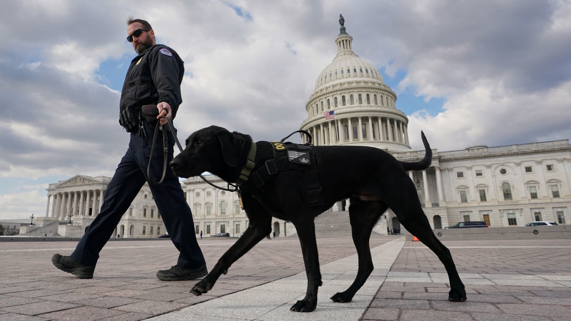 A U.S. Capitol police officer and his dog patrol the grounds of the Capitol, where tomorrow night U.S. President Joe Biden will deliver his the State of the Union Address, in Washington, February 6, 2023.