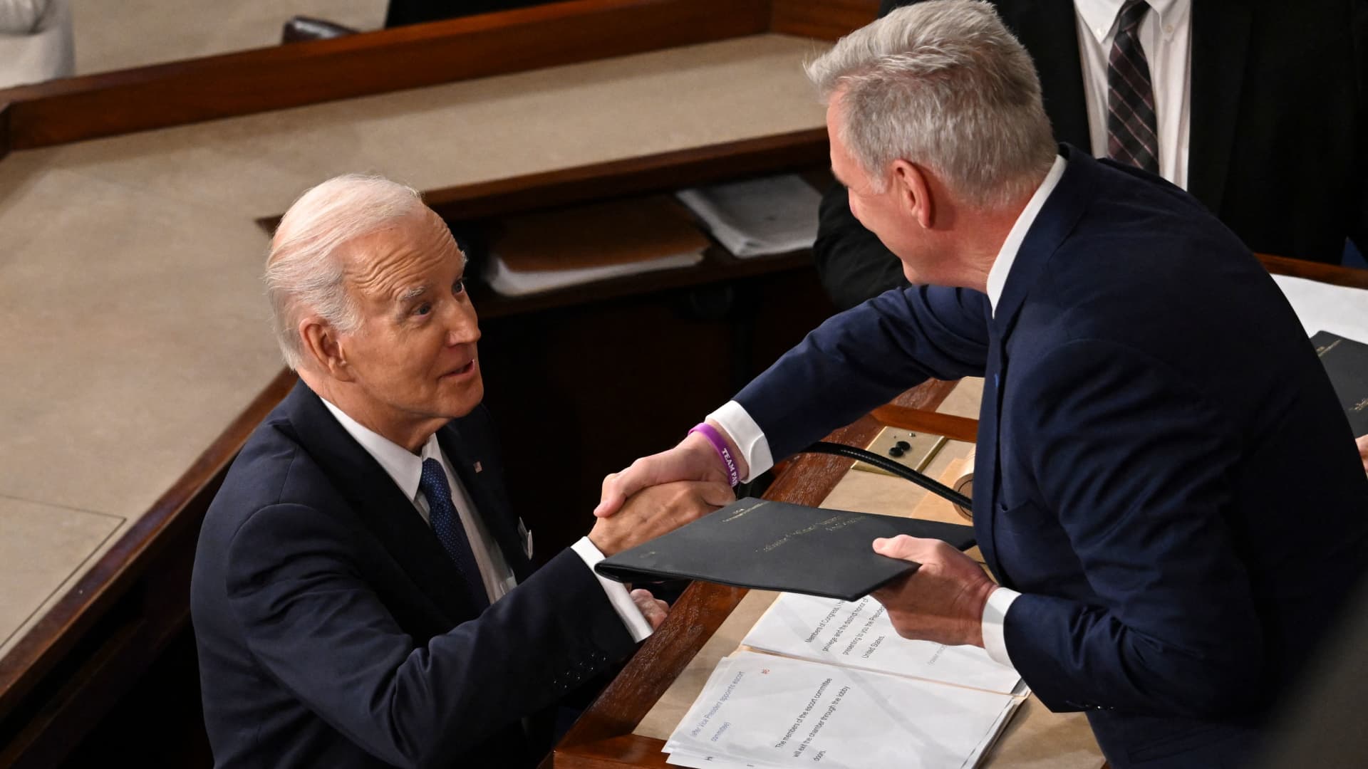 US Speaker of the House Kevin McCarthy (R), (R-CA), shakes hands with US President Joe Biden as he arrives to deliver the State of the Union address in the House Chamber of the US Capitol in Washington, DC, on February 7, 2023.