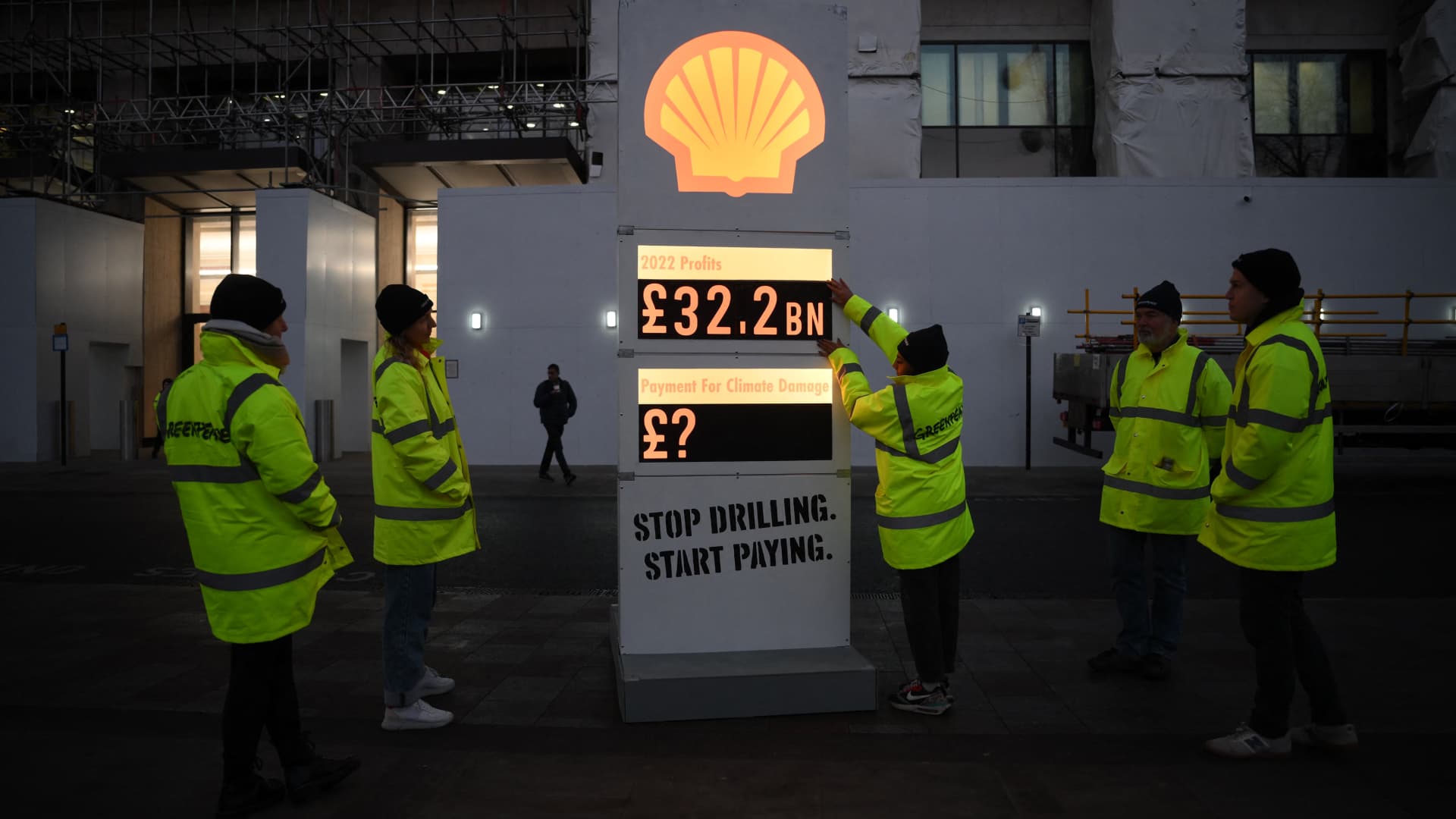 Activists from Greenpeace set up a mock-petrol station price board displaying the Shell's net profit for 2022 as they demonstrate outside the company's headquarters in London on Feb. 2, 2023.