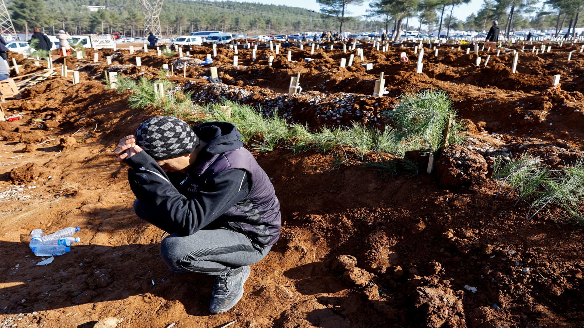 A man reacts next to the graves of victims of the deadly earthquake, in a cemetery in Kahramanmaras, Turkey February 9, 2023.