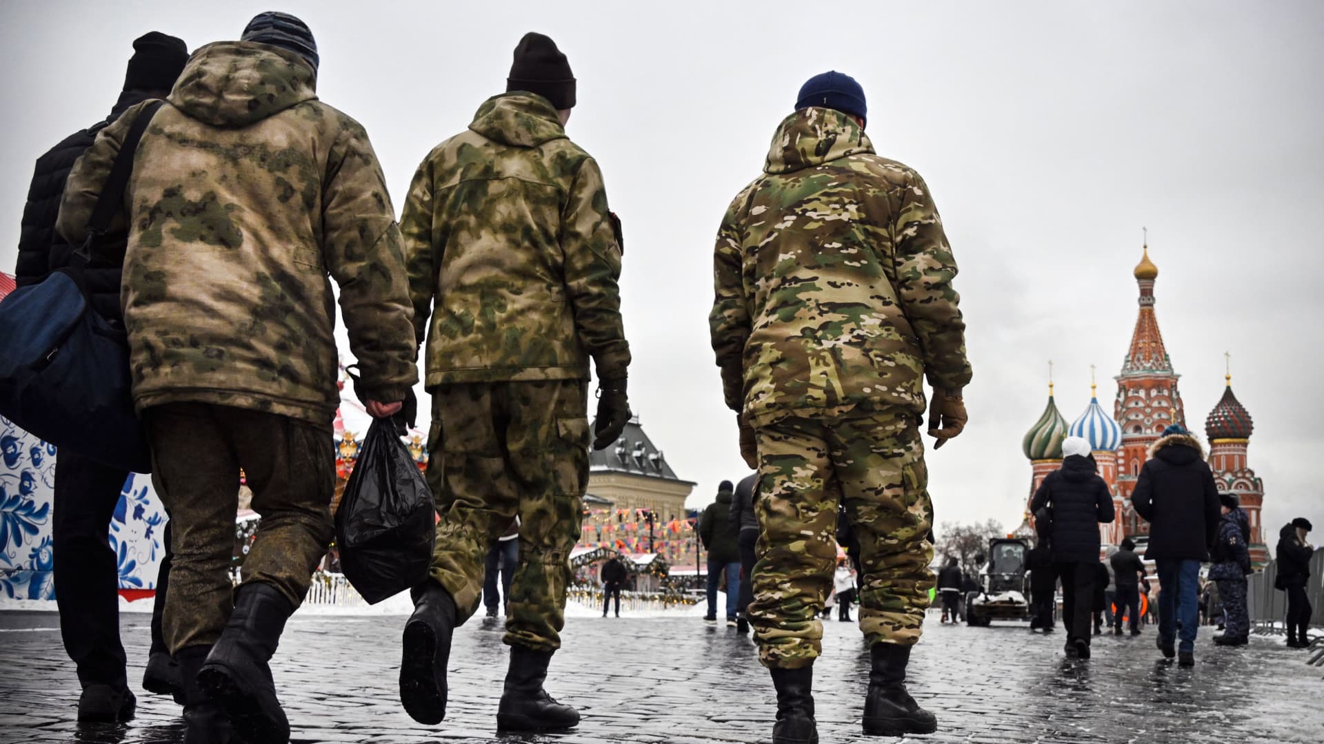 Men wearing military uniform walk along Red Square in front of St. Basil's Cathedral in central Moscow on February 13, 2023.