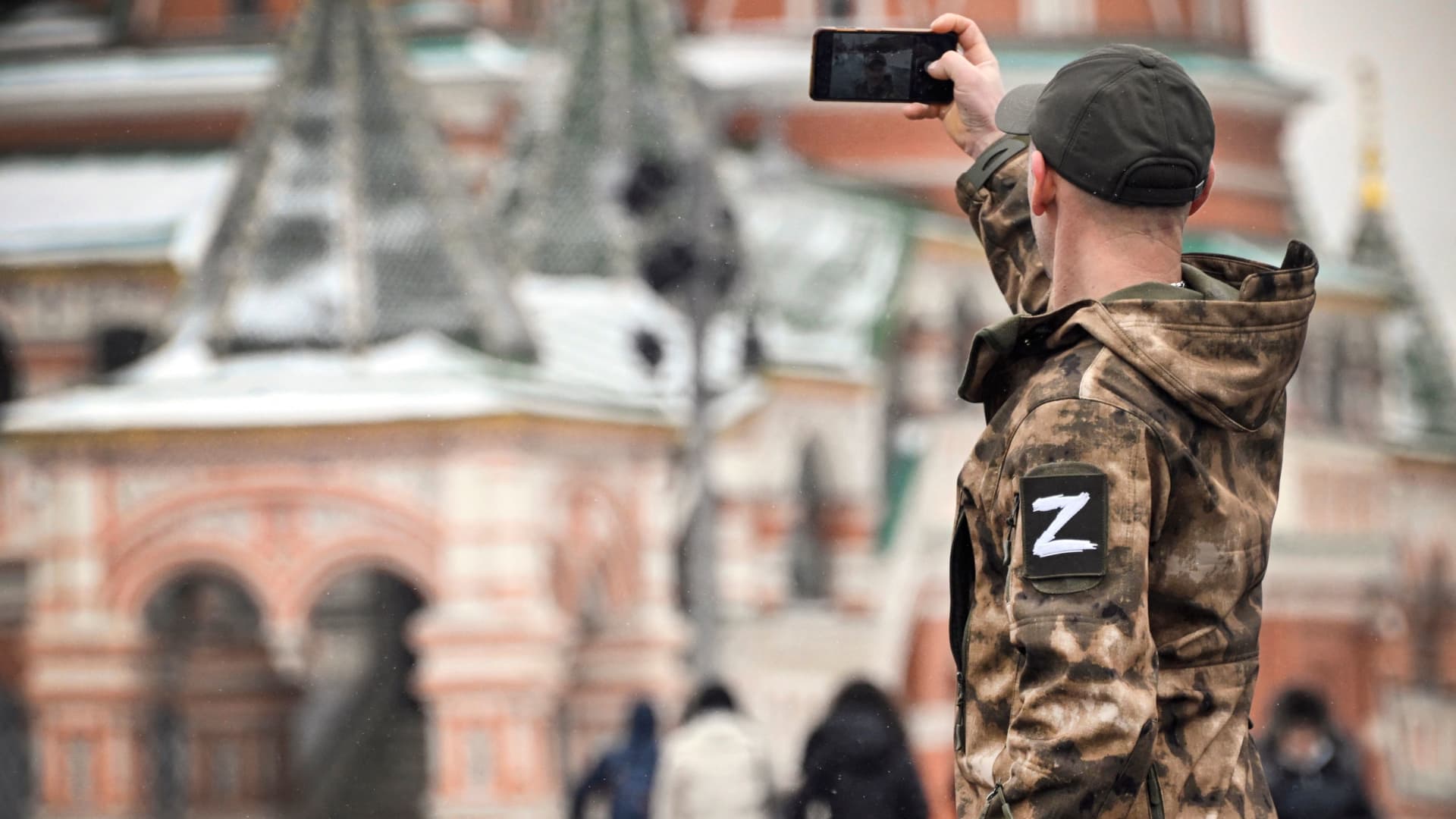 A man wearing military uniform with a Z letter, a tactical insignia of Russian troops in Ukraine, makes a selfie photo at Red Square in front of St. Basil's Cathedral in central Moscow on February 13, 2023.