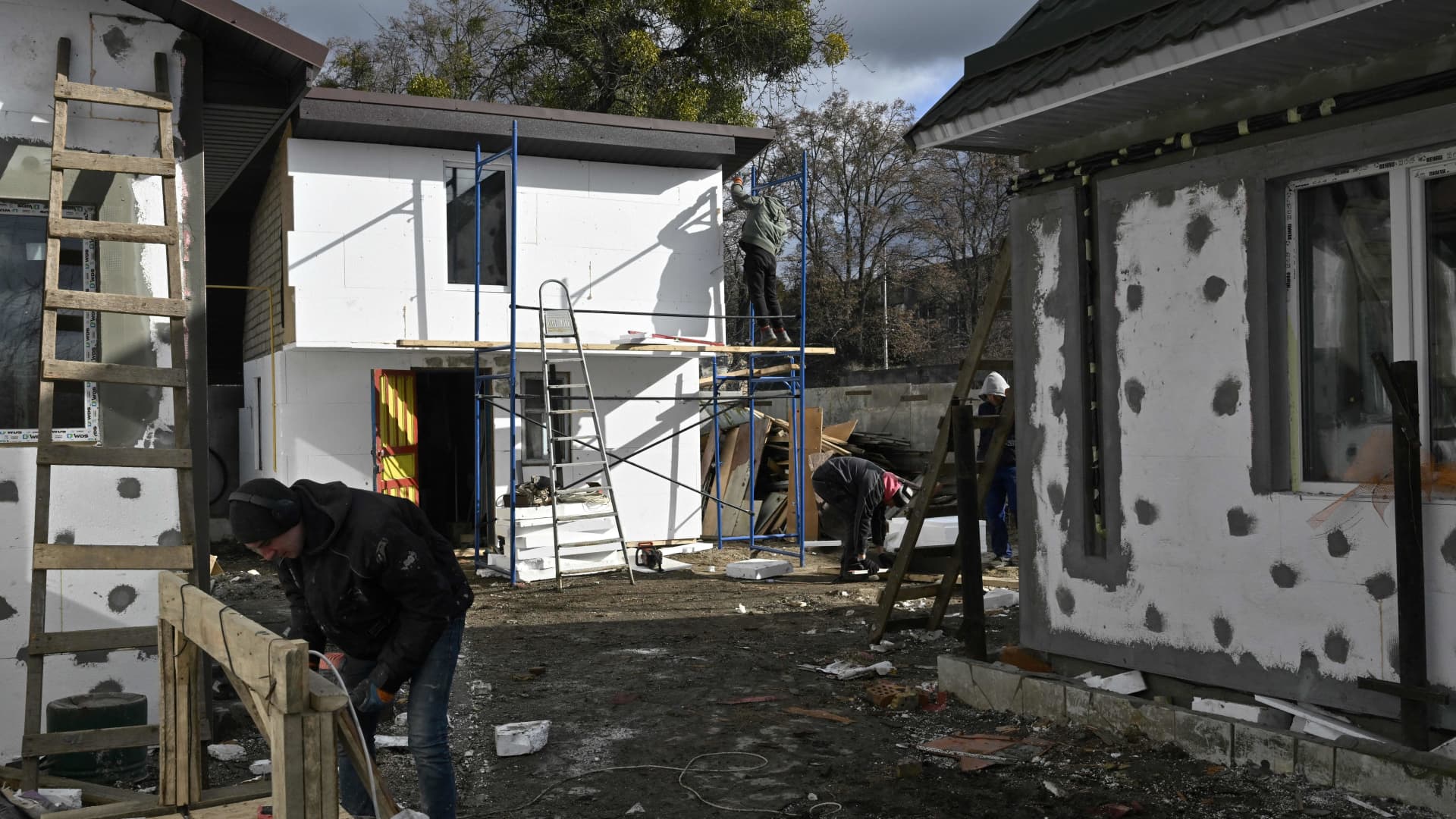 Workers rebuild a damaged house on Vokzalna street in Bucha, near Kyiv, on February 14, 2023, amid the Russian invasion of Ukraine.