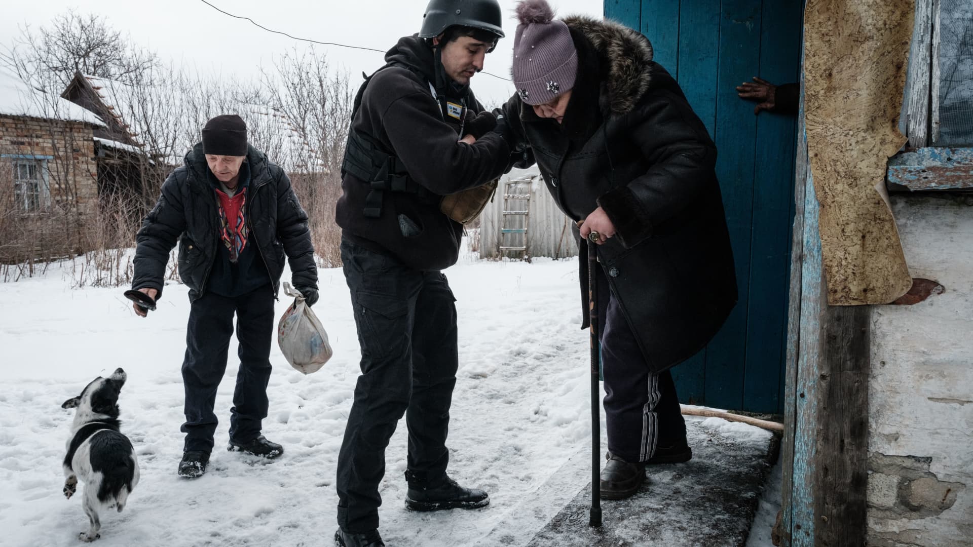 A volunteer Andrey (C), 38, helps Lydia Ivanovna (R), 62, to evacuate in Chasiv Yar on February 15, 2023, amid the Russian invasion of Ukraine.