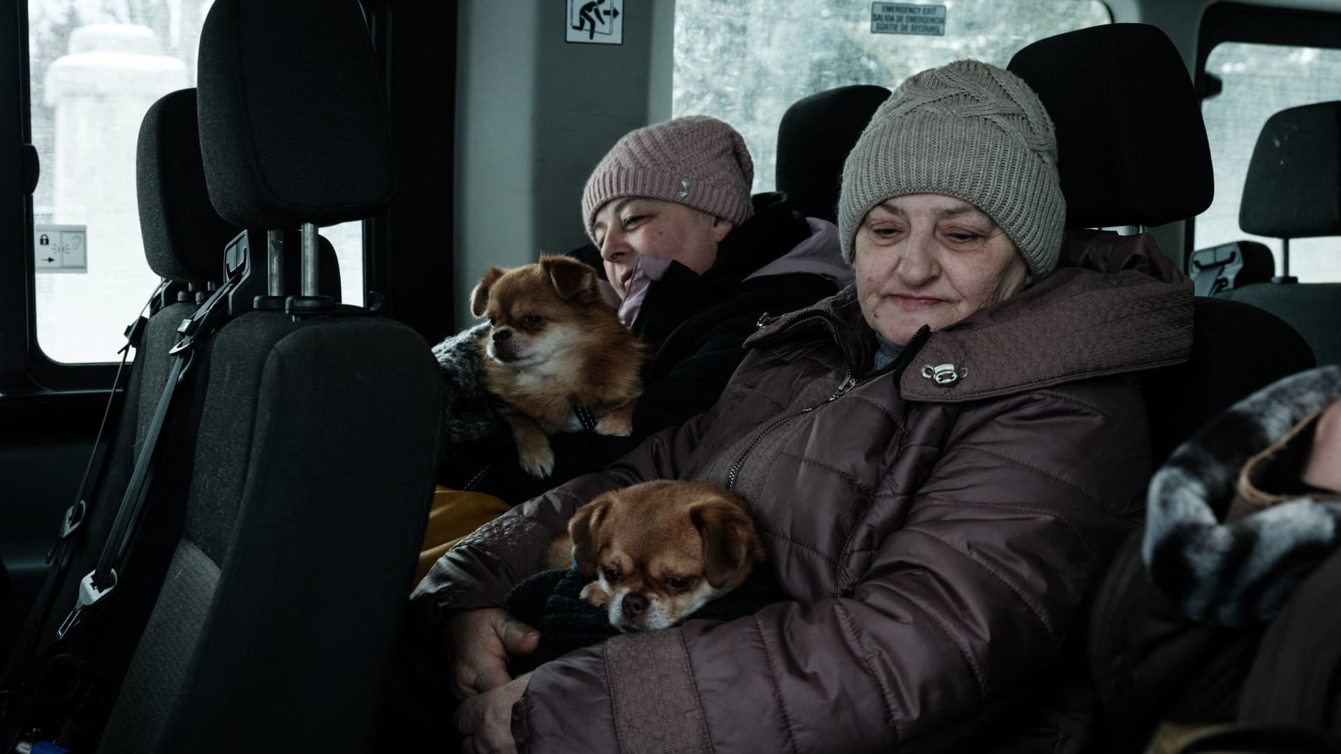 Lubov (R), 65, and her daugther Elena, 45, sit in the evacuation van with their dogs, in Chasiv Yar on February 15, 2023, amid the Russian invasion of Ukraine. - The minibus, operated by the charity Save Ukraine, picks its way through the snow-covered streets on the way to its next pick-up, taking advantage of a relative lull in the firing. 