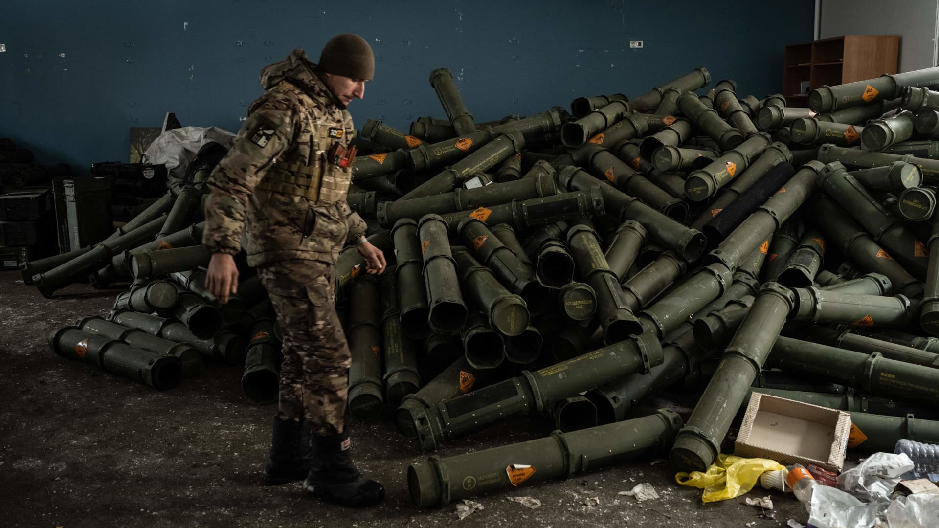 A Ukrainian serviceman of the 93rd brigade stands near a pile of empty mortar shell containers in Bakhmut on February 15, 2023, amid the Russian invasion of Ukraine. 