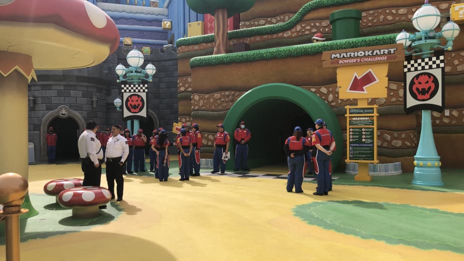Os funcionários do Universal Studios Hollywood aguardam os convidados do lado de fora de Mario Kart: Bowser's Challenge no Super Nintendo World.