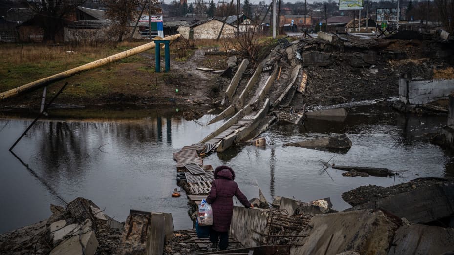 A woman crosses a destroyed bridge in Bakhmut, Donetsk region, on January 6, 2023, amid the Russian invasion of Ukraine. Russia and Ukraine have both suffered heavy casualties in the fight for Bakhmut, and most of the city's pre-war population of 70,000 have left for safer territory, leaving behind cratered roads and buildings reduced to rubble and twisted metal. (Photo by Dimitar DILKOFF / AFP) (Photo by DIMITAR DILKOFF/AFP via Getty Images)
