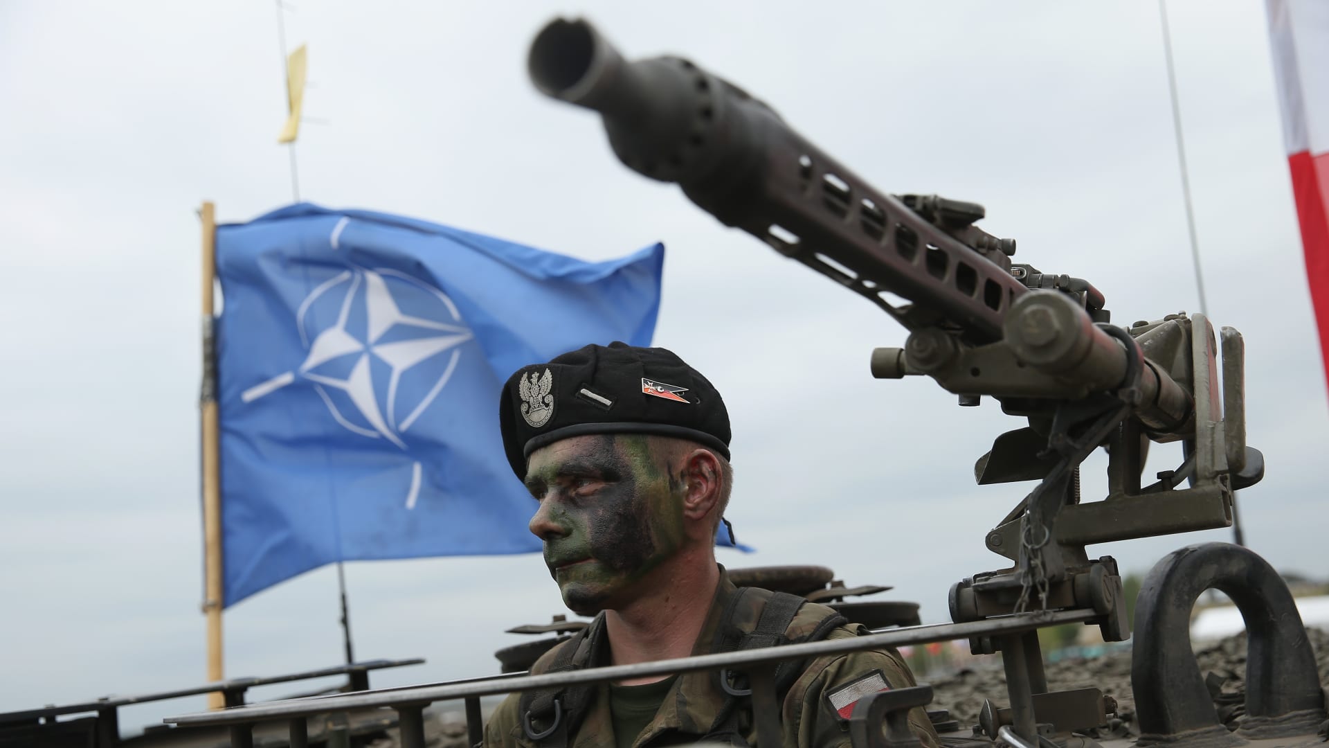 A soldier of the Polish Army sits in a tank as a NATO flag flies behind during the NATO Noble Jump military exercises of the VJTF forces on June 18, 2015 in Zagan, Poland.