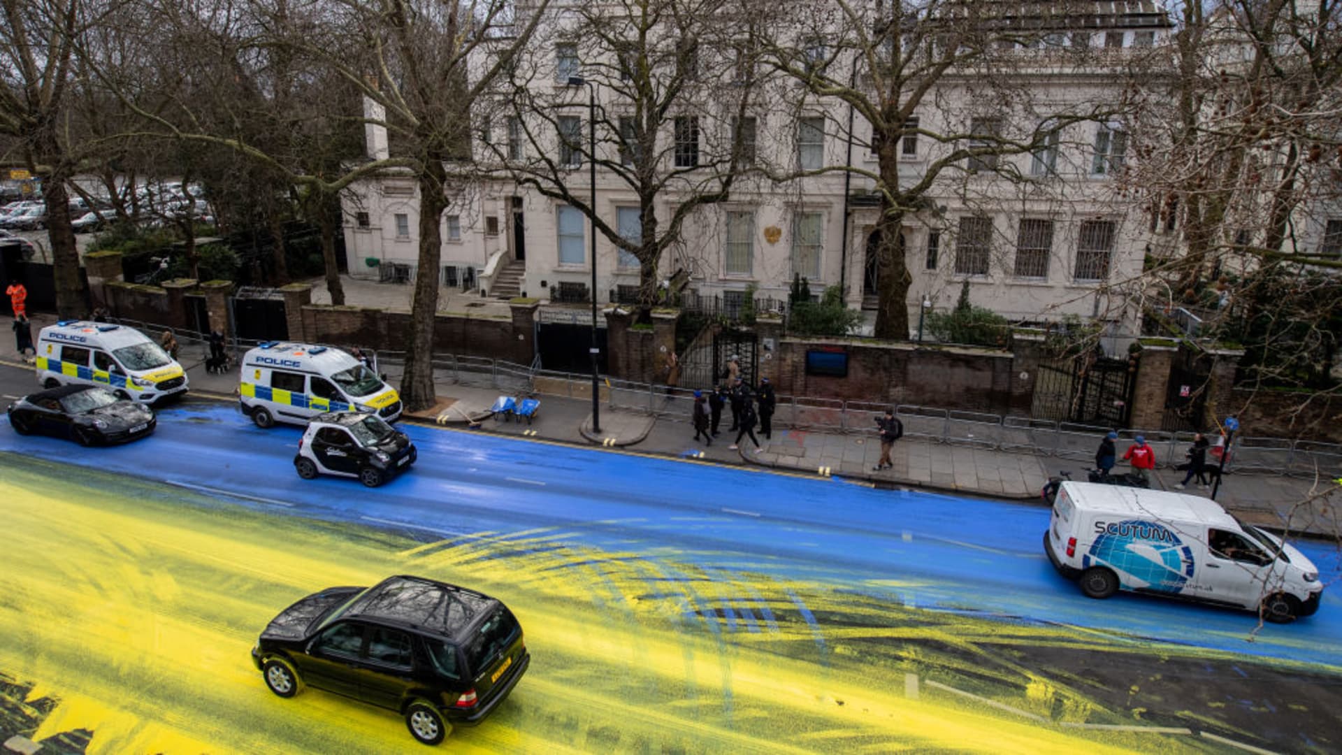 Activists from political campaign group Led By Donkeys poured paint onto the road to create a giant Ukrainian flag outside the Russian Embassy on February 23, 2023 in London, England. The group created the flag using washable paint poured onto the road and then driven through by passing vehicles.