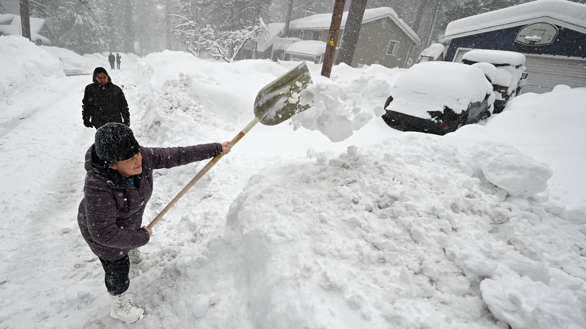 Norma Miro, from La Puente, shovels snow out of the driveway of the rental property she shared with her family for the last week in Wrightwood so they can move their vehicles on Wednesday, Mar. 1, 2023.