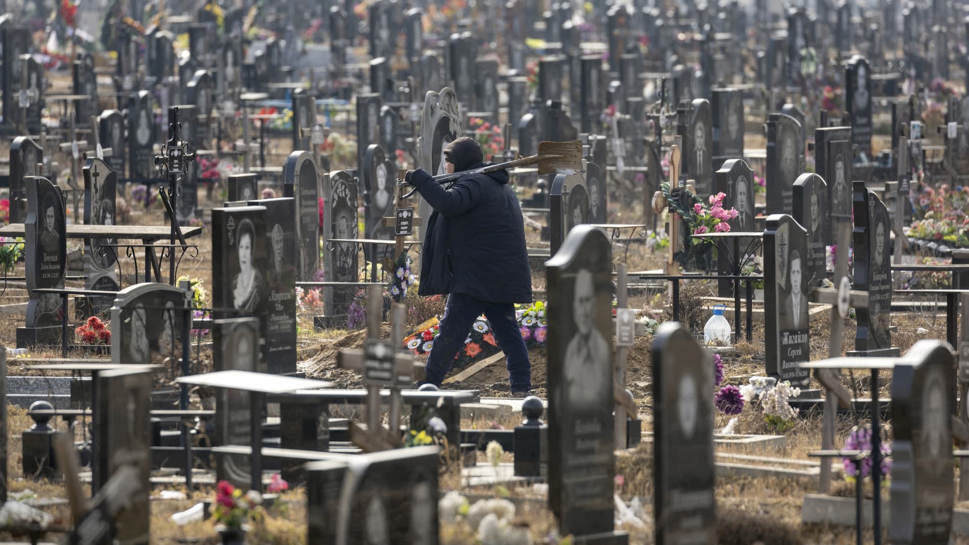 A grave digger walks through a cemetery on March 07, 2023 in Kharkiv, Ukraine. Last February, Russia's military invaded Ukraine from three sides and launched airstrikes across the country.