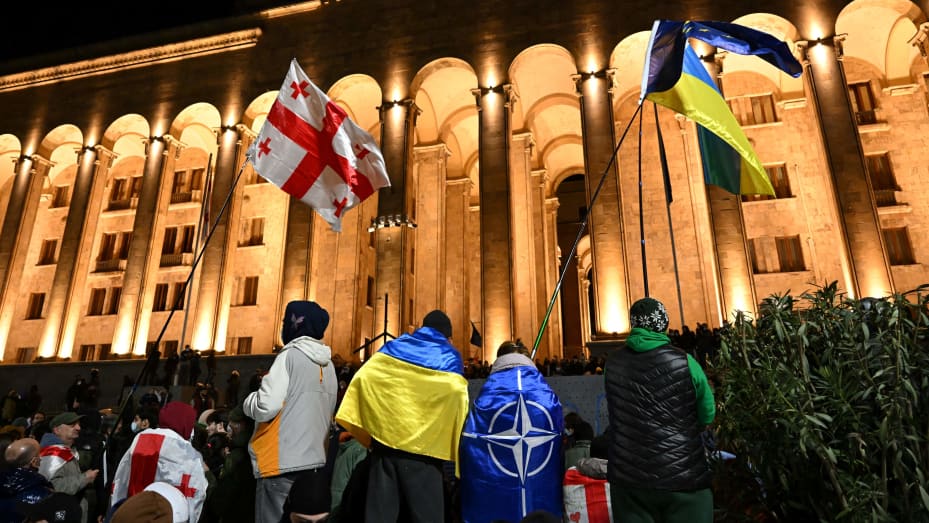 Protesters wave Georgian, Ukrainian and NATO flags during clashes in Tbilisi on March 7, 2023.