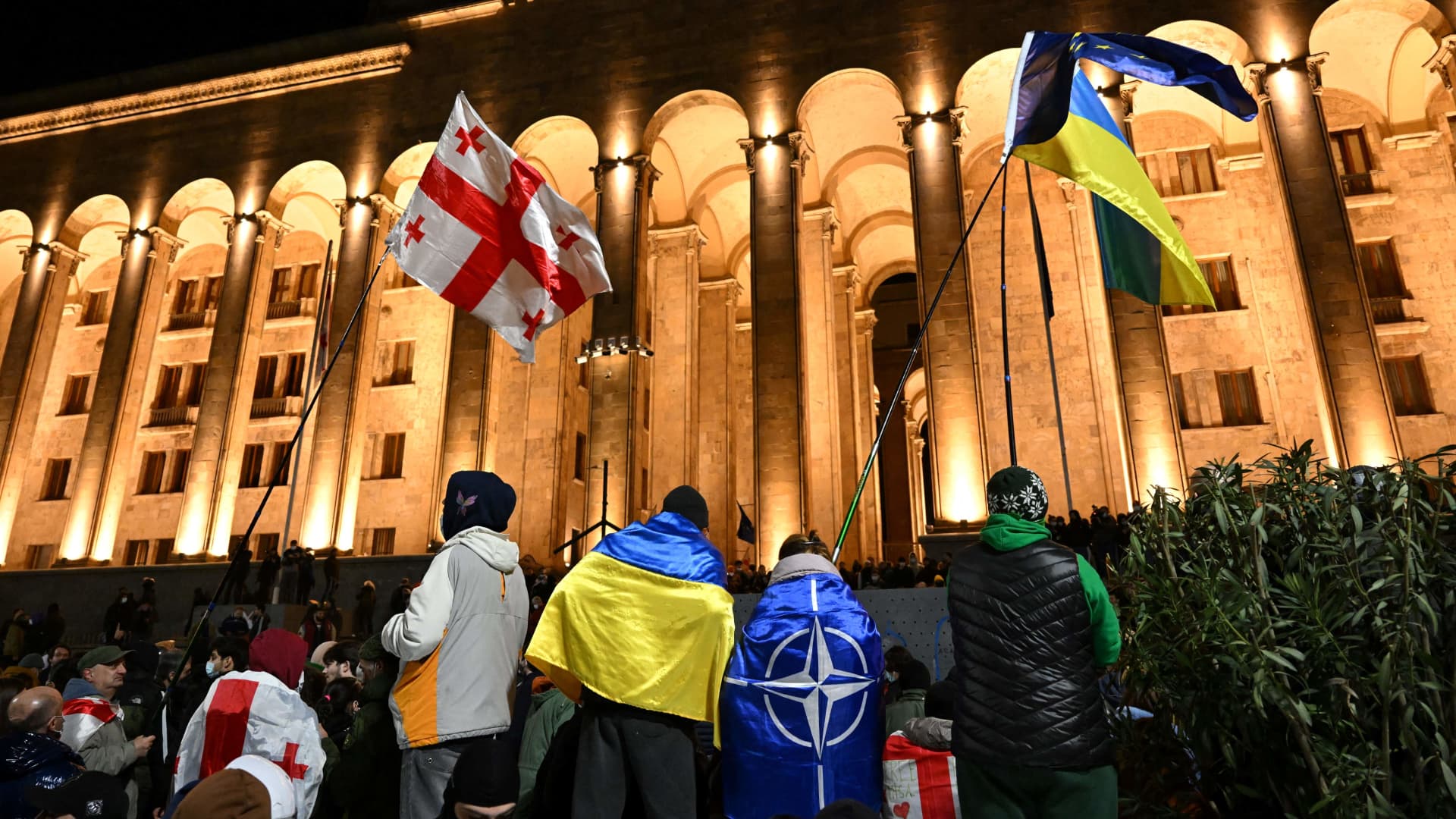 Protesters wave Georgian, Ukrainian and NATO flags during clashes in Tbilisi on March 7, 2023.