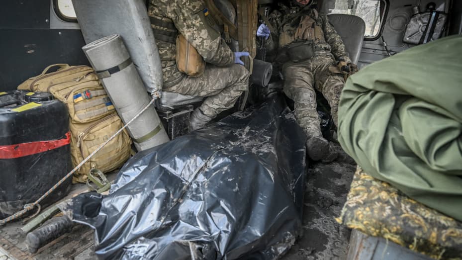 EDITORS NOTE: Graphic content / Ukrainian servicemen sit inside a field ambulance next to their fallen comrade as they come back from the front line near the city of Bakhmut, on March 8, 2023, amid the Russian invasion of Ukraine.