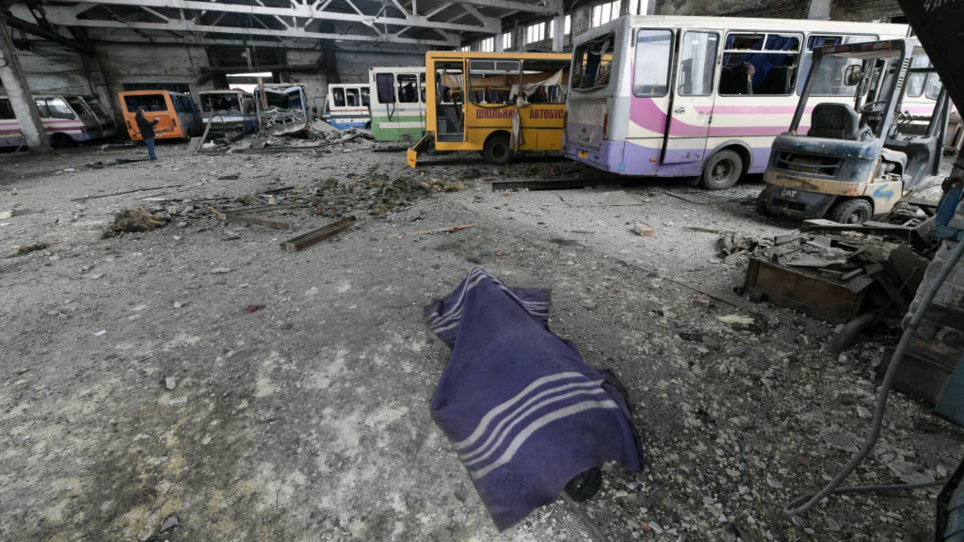 A body lays on the ground at bus depot after an artillery attack as one killed and another wounded in Volnovakha on the Russian-controlled territory on March 09, 2023.