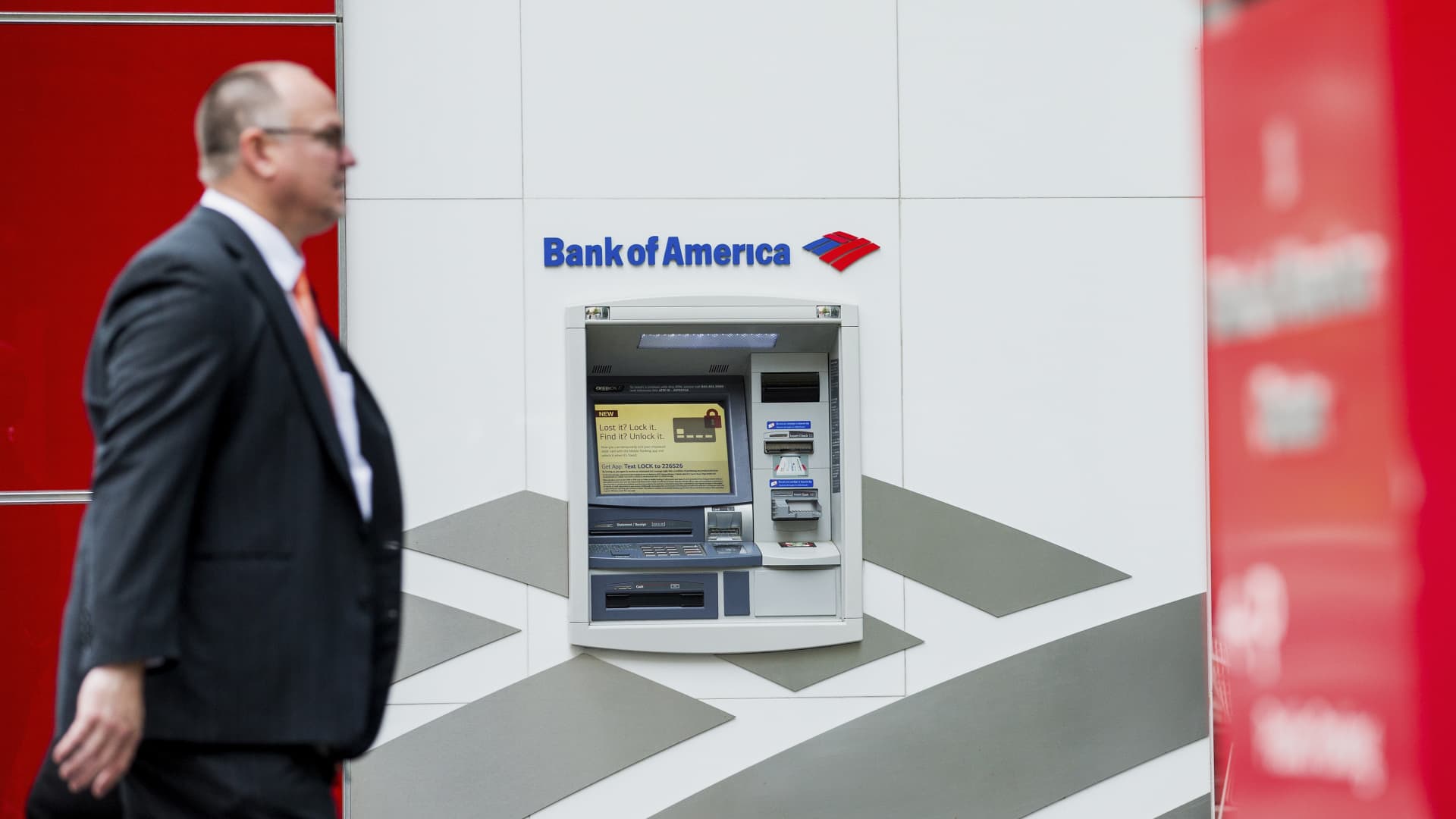 A man walks past an automated teller machine (ATM) outside Bank of America Corp. headquarters in Charlotte, North Carolina, U.S., on Monday, May 2, 2016.