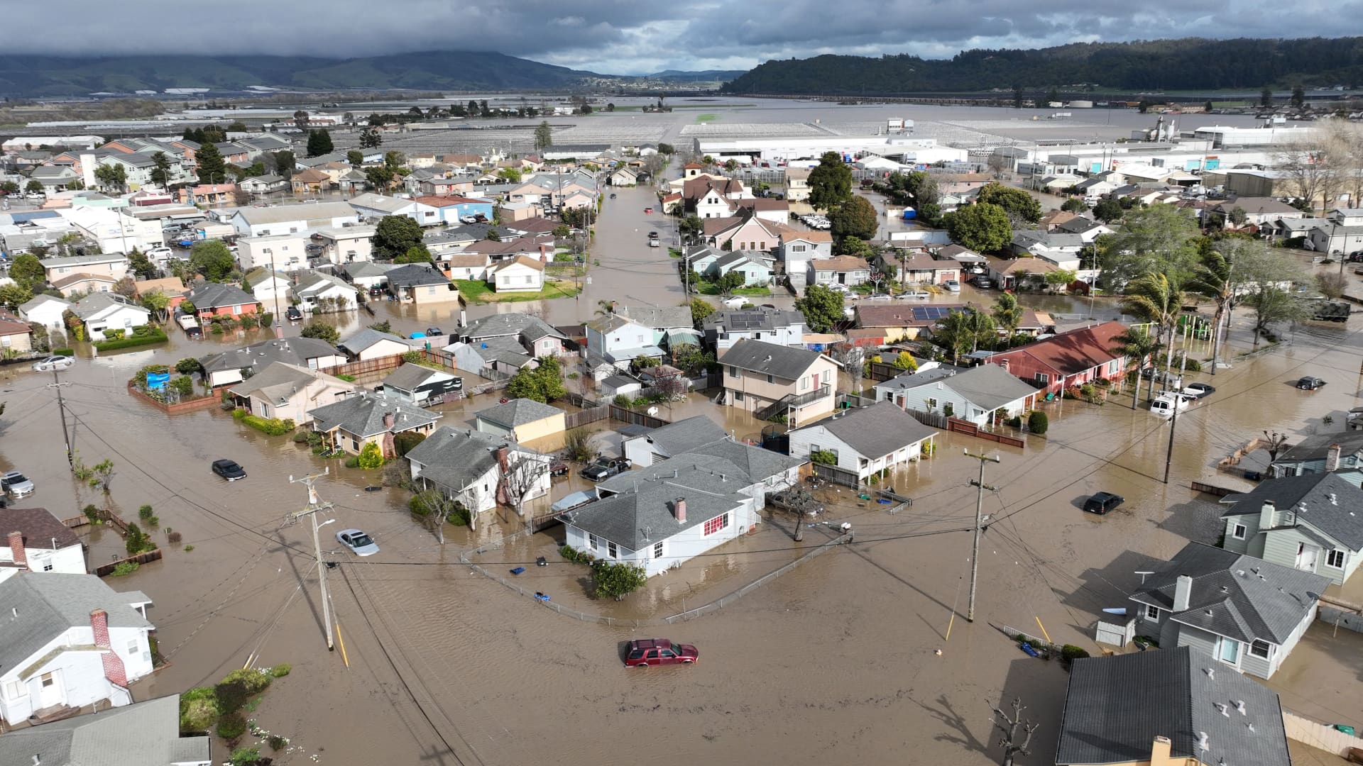 This aerial photograp shows vehicles and homes engulfed by floodwaters in Pajaro, California on Saturday, March 11, 2023.