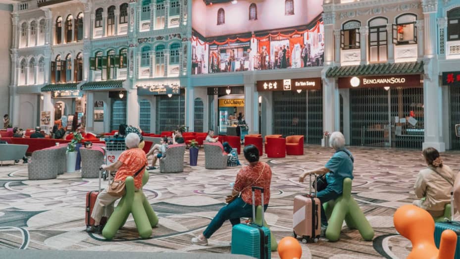 Passengers in front of stores furnished to look like Peranakan shophouses in Terminal 4.