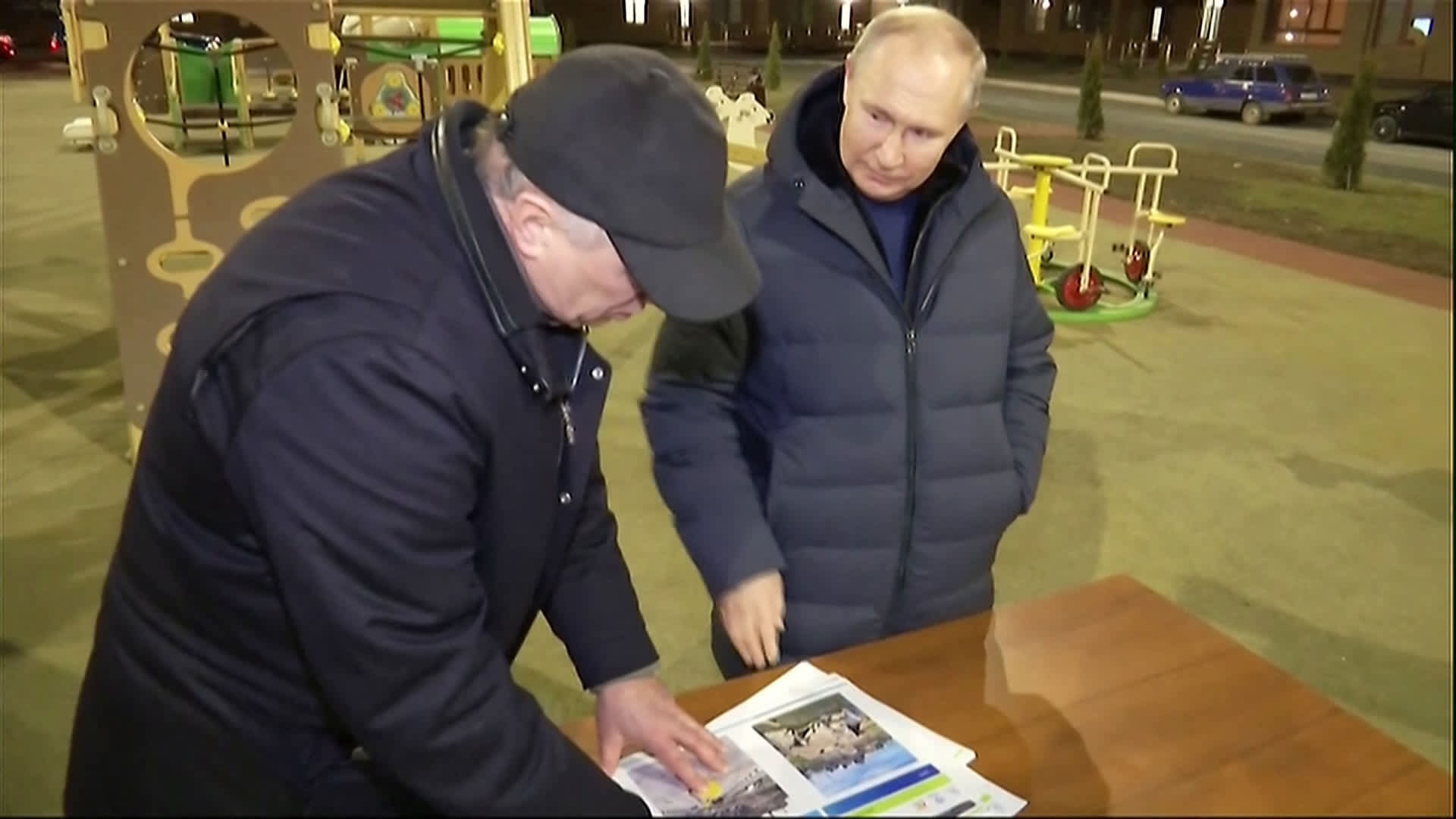 Russian President Vladimir Putin and Deputy Prime Minister Marat Khusnullin look at reconstruction illustrations during a visit to the Ukrainian city of Mariupol on March 18, 2023.