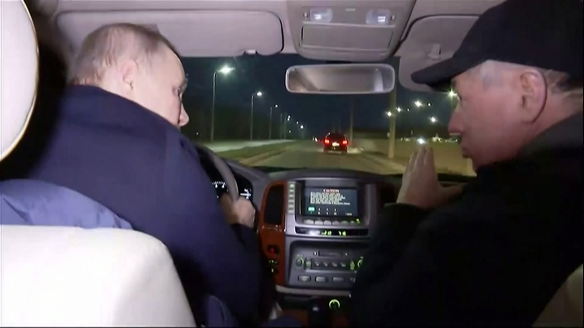 Russian President Vladimir Putin (seen here in a grab taken from video released by Russian broadcaster VGTRK on March 19, 2023) driving with Deputy Prime Minister Marat Khusnullin as he visits the Ukrainian city of Mariupol.