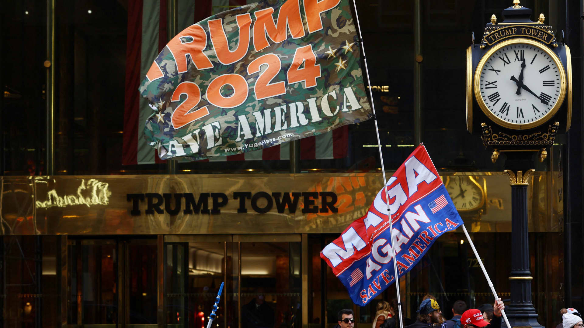 A man who identified himself as Don Cini, a supporter of former U.S. President Donald Trump, carries a Trump campaign flag outside Trump Tower in midtown Manhattan in New York City, New York, March 20, 2023.