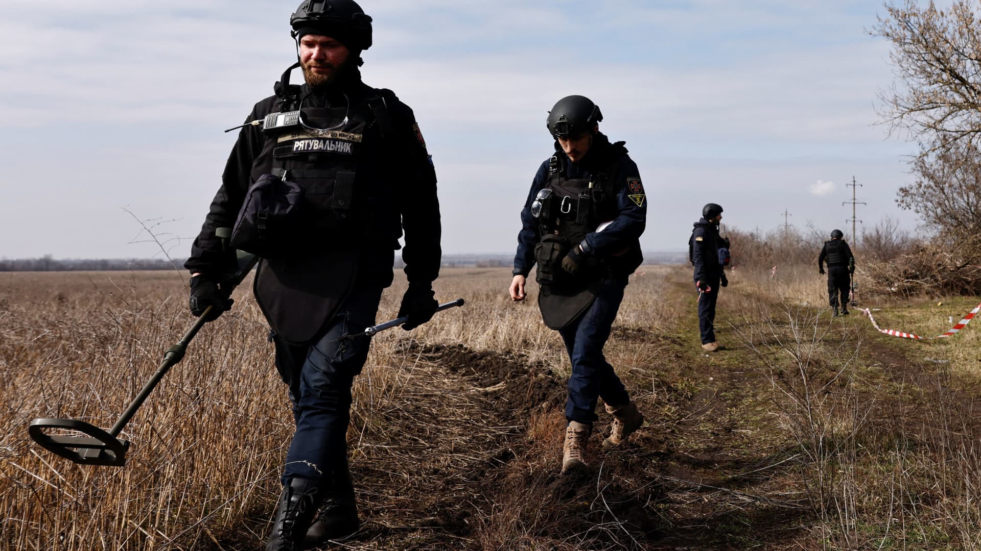 A member of the de-mining department of the Ukrainian Emergency Services prepares to survey an area of farmland and electric power lines for land mines and other unexploded ordnance for electricians to access power towers damaged by Russian strikes in order to repair them, in Korovii Yar, in the Eastern Donetsk region of Ukraine, on March 20, 2023.