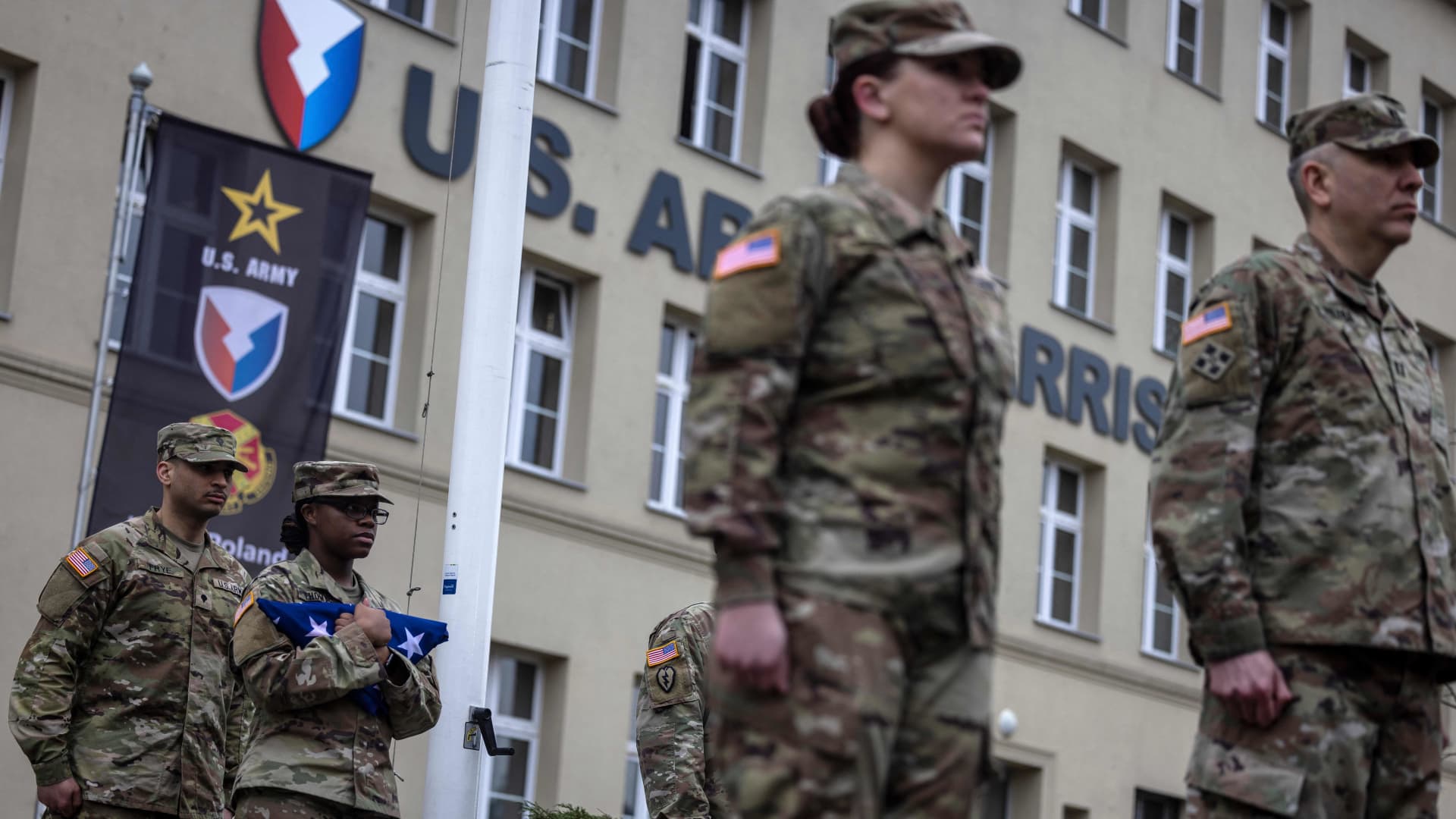 An US soldier holds the US flag as she takes part in the inauguration ceremony, transforming the Area Support Group Poland into the permanent US Army Garrison Poland, at Camp Kosciuszko in Poznan, on March 21, 2023. 