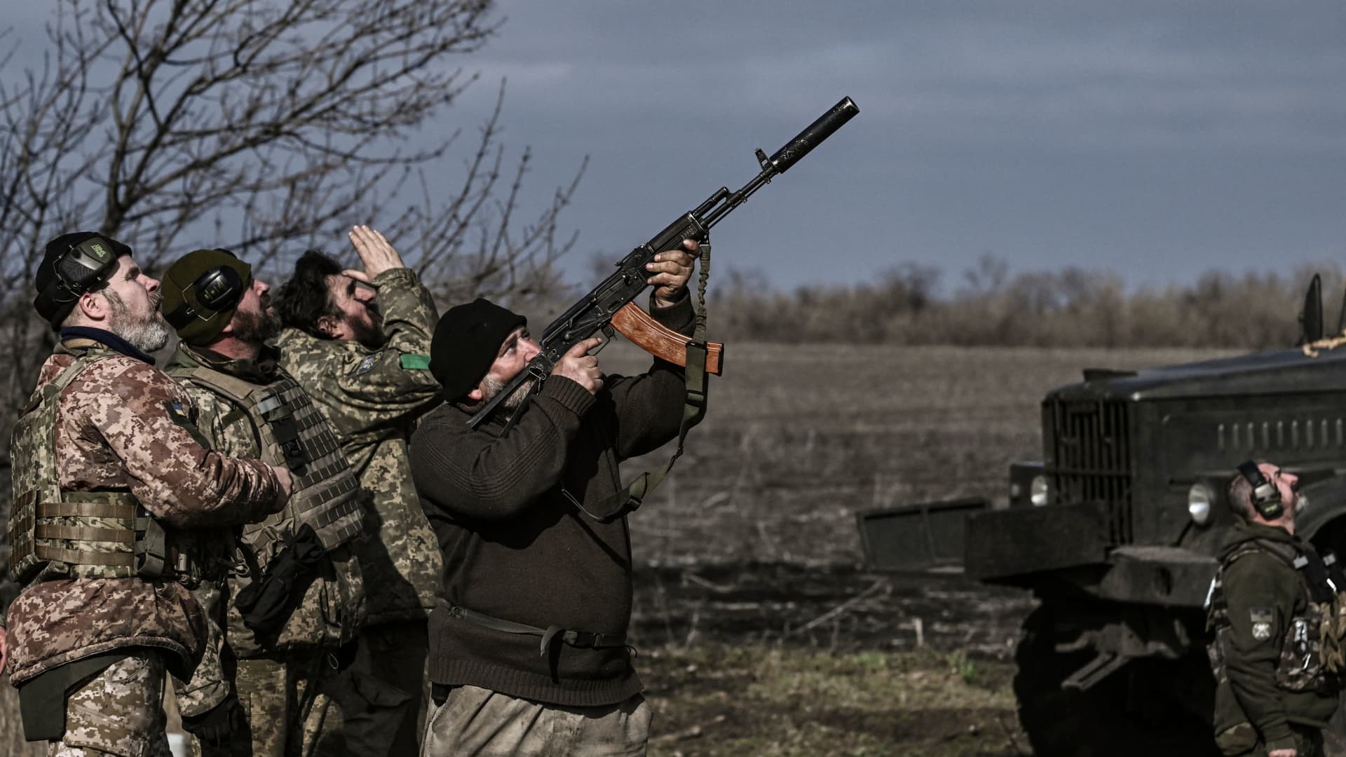 A Ukrainian serviceman fires with his rifle at a drone flying above their position near Bakhmut on March 20, 2023.