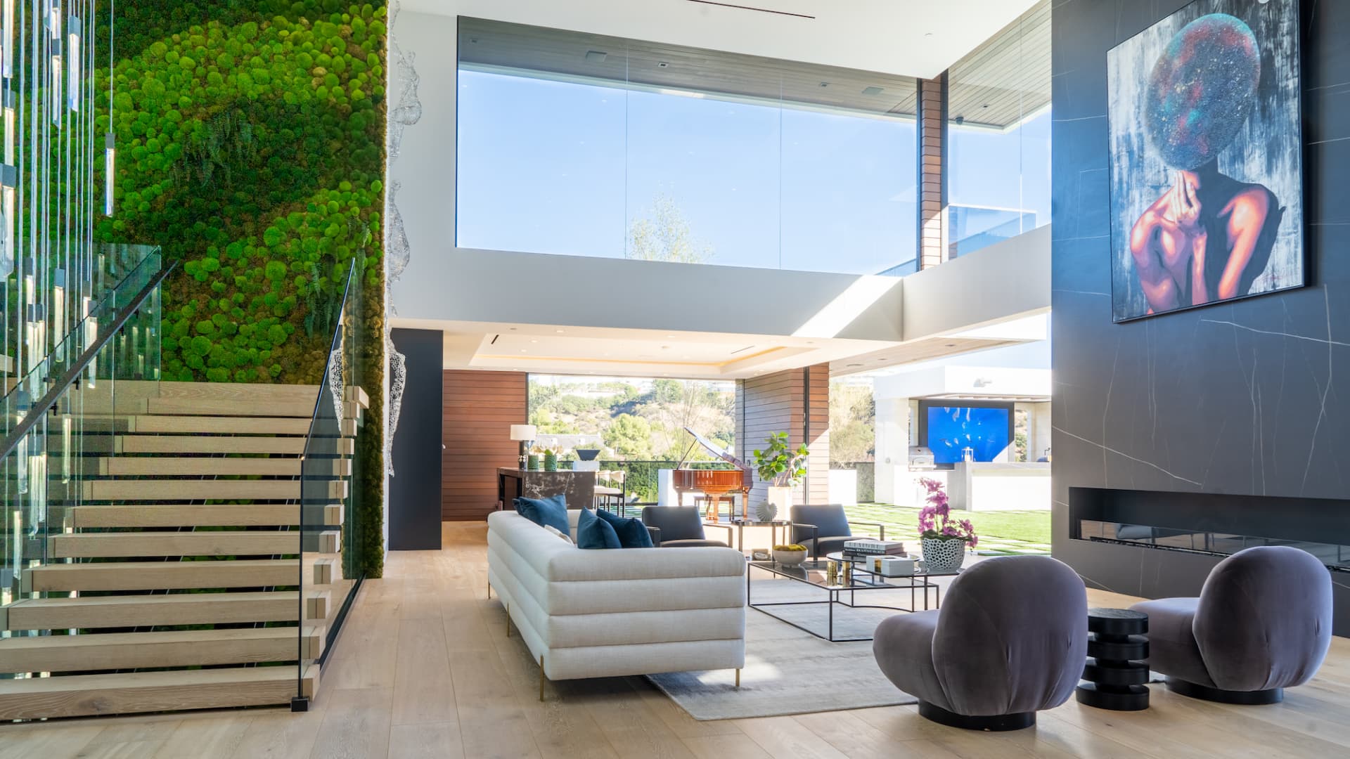 The home's impressive foyer includes double height ceilings and glass walls that open to the pool deck and outdoor bar.