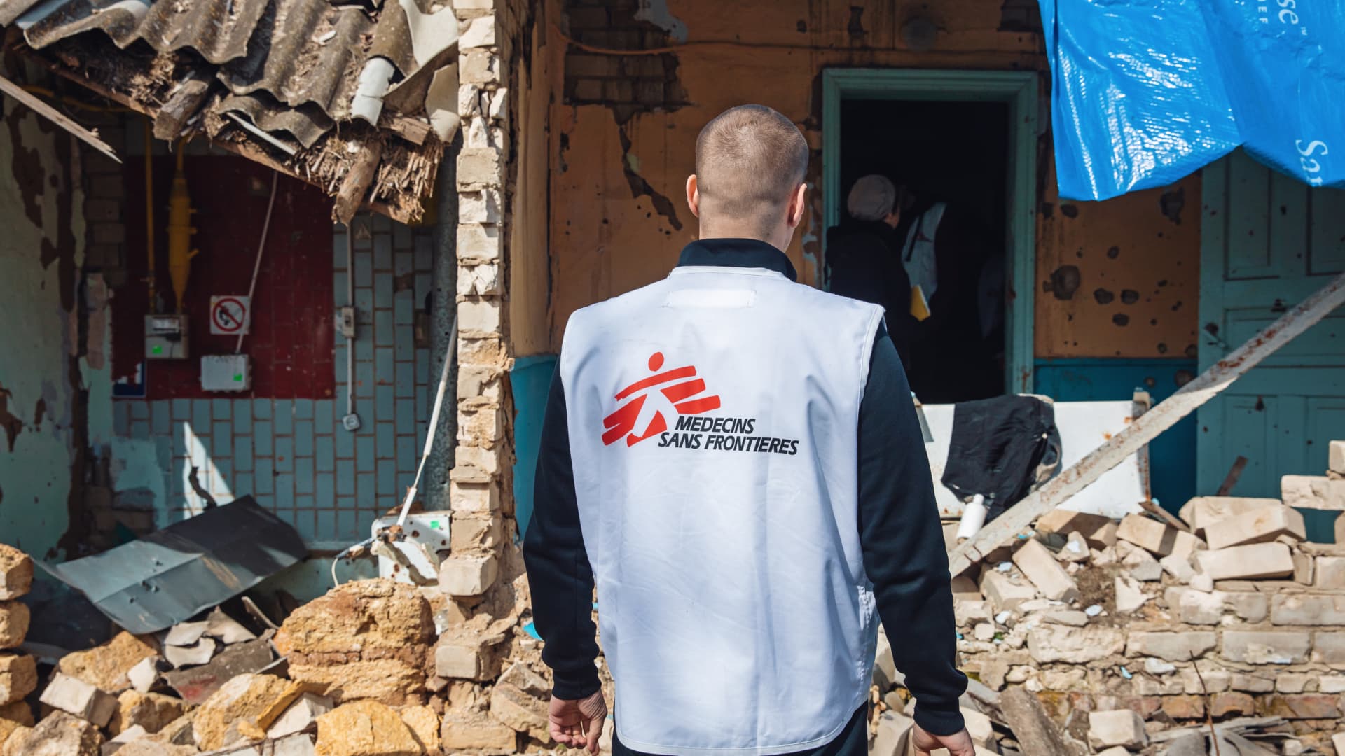 A volunteer from the humanitarian mission Doctors Without Borders (Médecins Sans Frontières (MSF) inspects a destroyed house on the outskirts of Kherson.