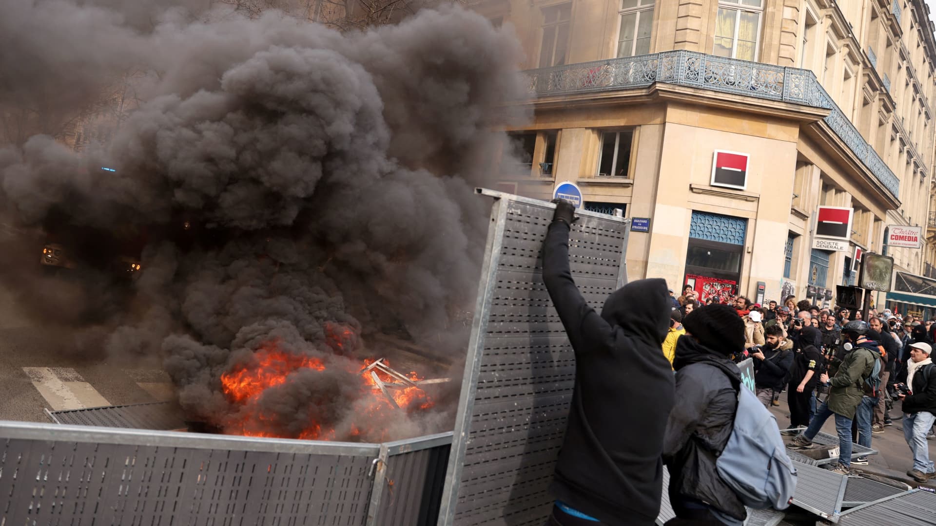 Protesters hold construction barriers next to burning garbage bins amid clashes during a demonstration during the ninth day of nationwide strikes and protests against French government's pension reform, in Paris, France, March 23, 2023. 