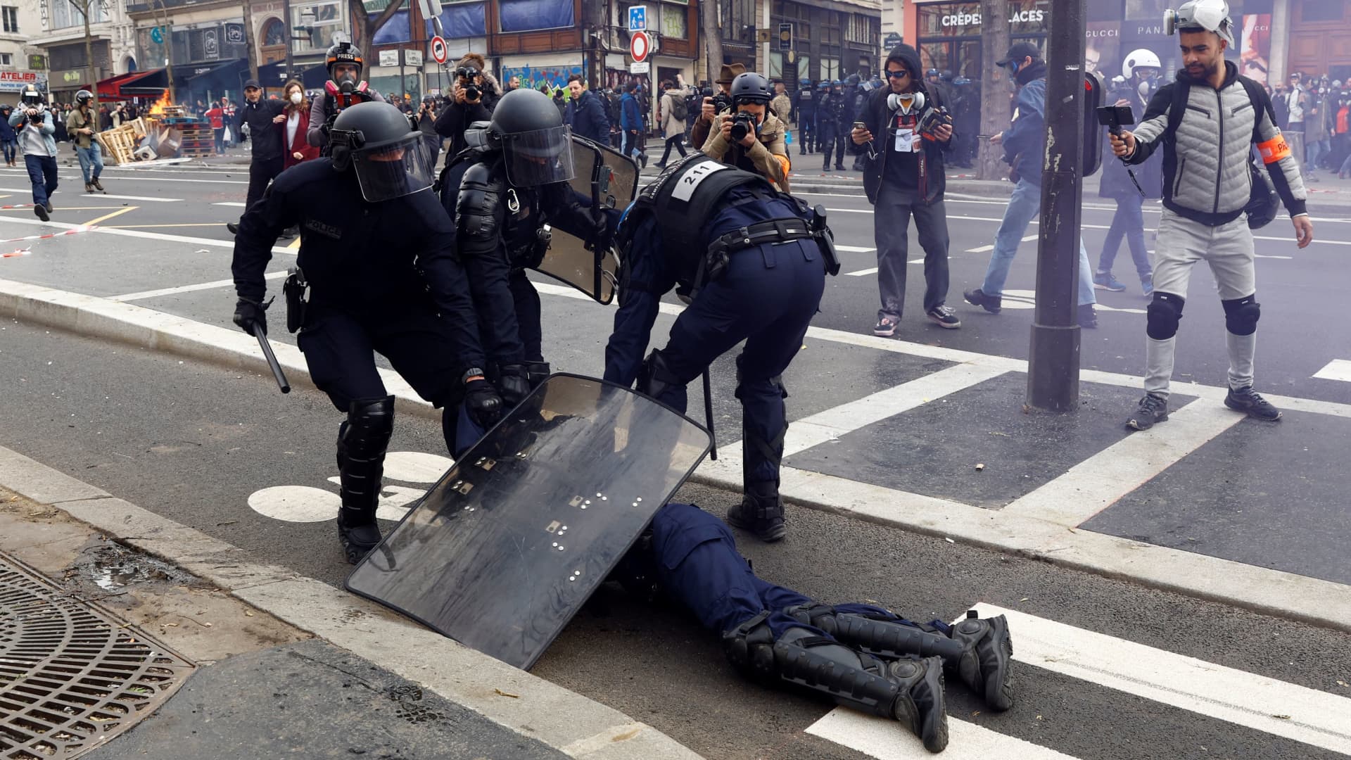 A French police officer in riot gear, injured during clashes with protesters, is given help at a demonstration during the ninth day of nationwide strikes and protests against French government's pension reform, in Paris, France, March 23, 2023. 