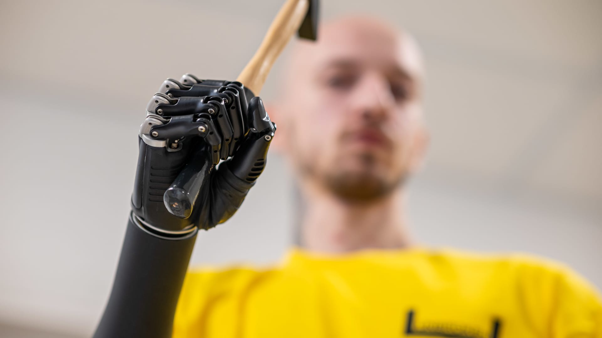 A man with a bionic prosthetic hand shows how a prosthesis functions, holding a hammer in his prosthetic hand on March 23, 2023 in Lviv, Ukraine. 