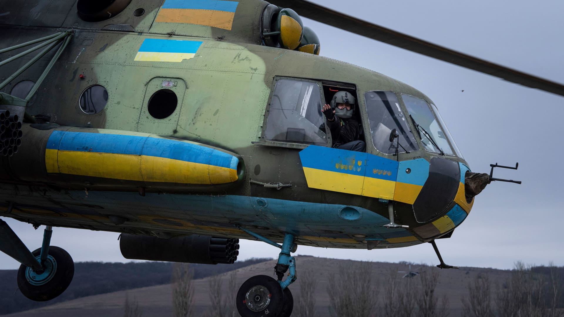A Ukrainian pilot waves to his comrades from an Mi-8 combat helicopter during a combat mission in Donetsk region, Ukraine, Saturday, March 18, 2023.