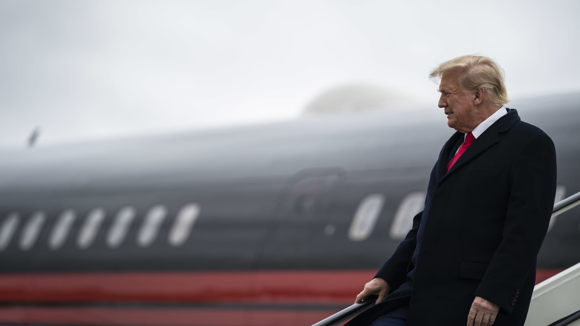 Former President Donald Trump disembarks his plane as he lands at Quad City International Airport in route to Iowa on Monday, March 13, 2023, in Moline, IL.