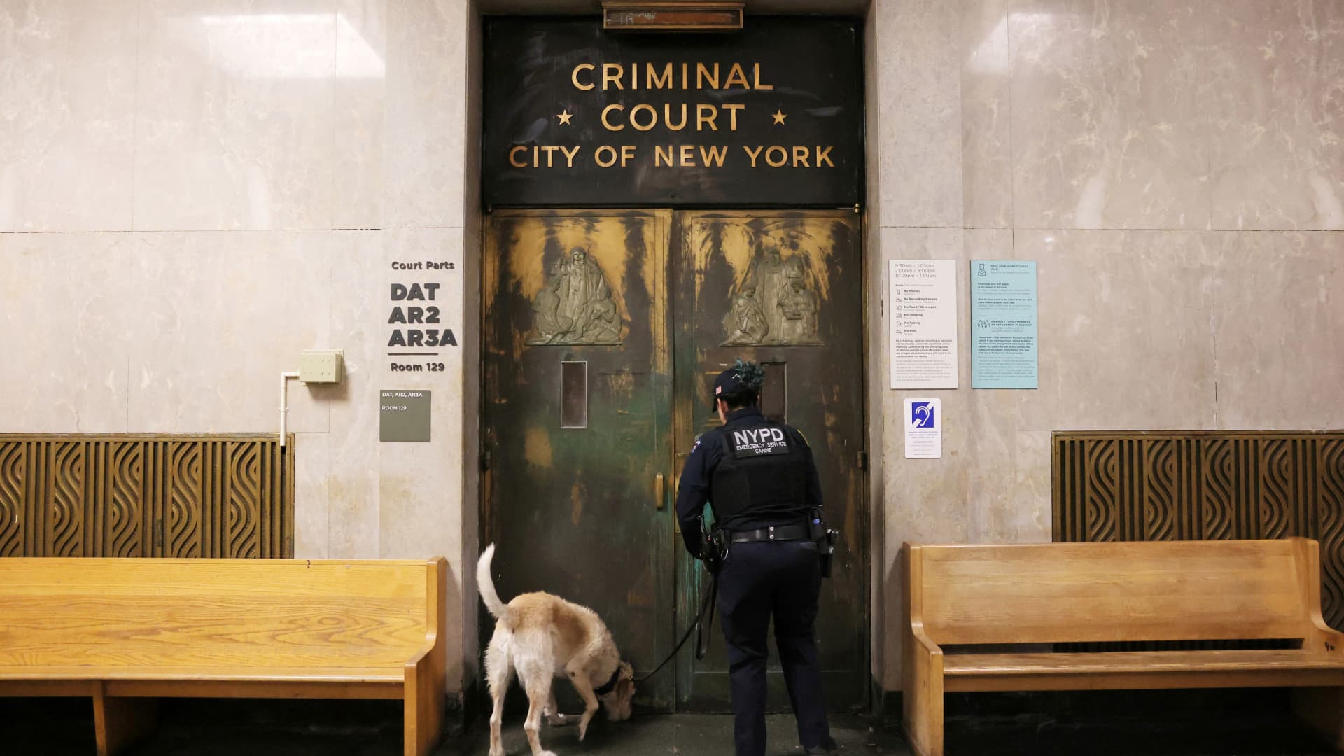 An officer from the New York City Police Department (NYPD) Canine Unit checks outside the Manhattan Criminal Court in New York City, U.S., March 27, 2023. Manhattan District Attorney Alvin Bragg's office is investigating $130,000 paid in the final weeks of former U.S. President Donald Trump's 2016 election campaign to Stormy Daniels, a porn star who said she had a sexual encounter with Trump in 2006 when he was married to his current wife Melania. REUTERS/Andrew Kelly