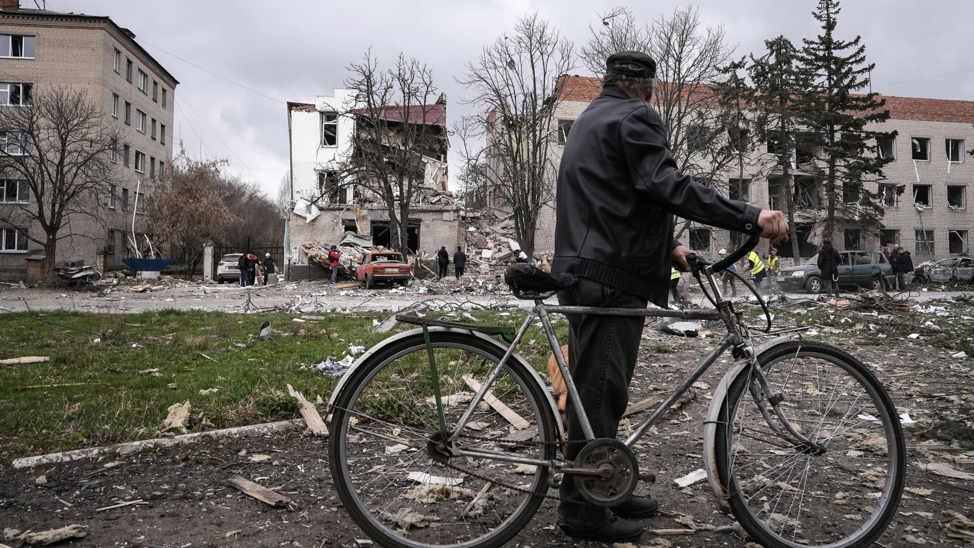 A man with a bicycle looks at destroyed buildings in the city centre on March 27, 2023 in Sloviansk, Ukraine. 