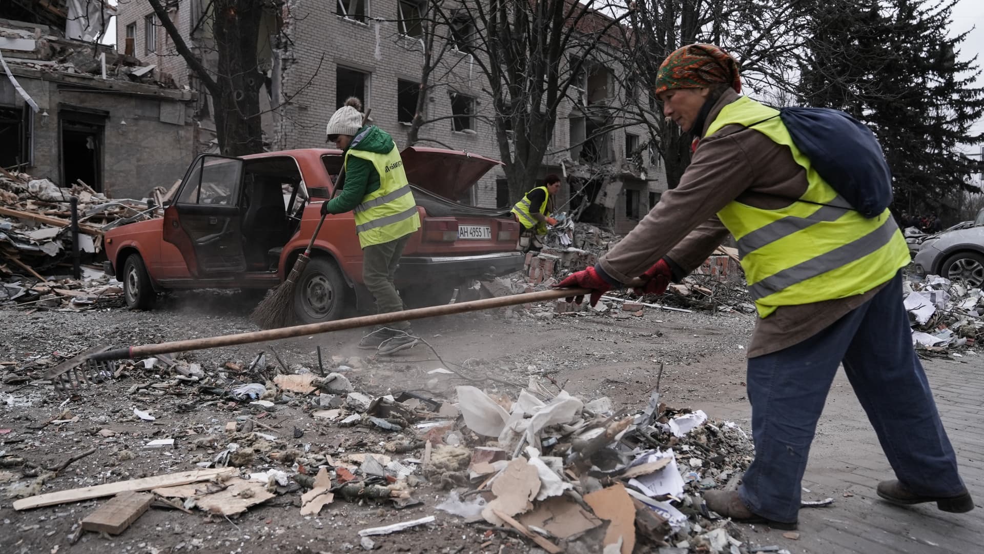 Utility workers clean up debris near destroyed buildings in the city centre on March 27, 2023 in Sloviansk, Ukraine. 