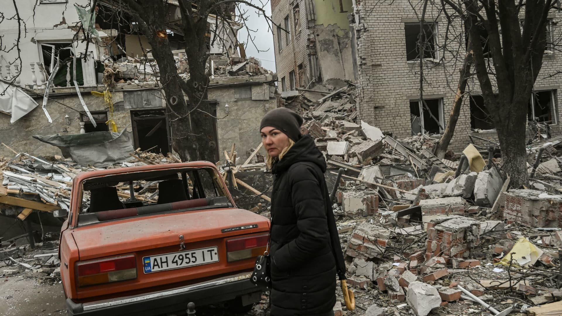 A woman stands in front of a destroyed building after a deadly strike in the city of Sloviansk, on March 27, 2023.